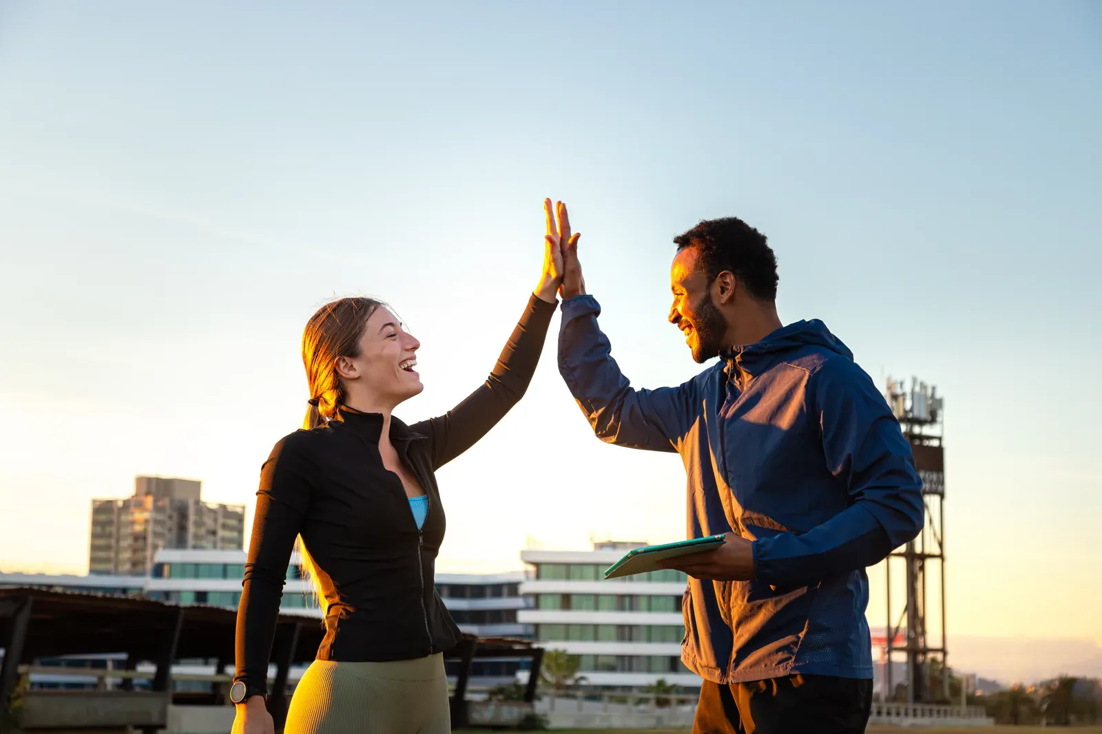 A fitness instructor and client sharing a high five after a training session