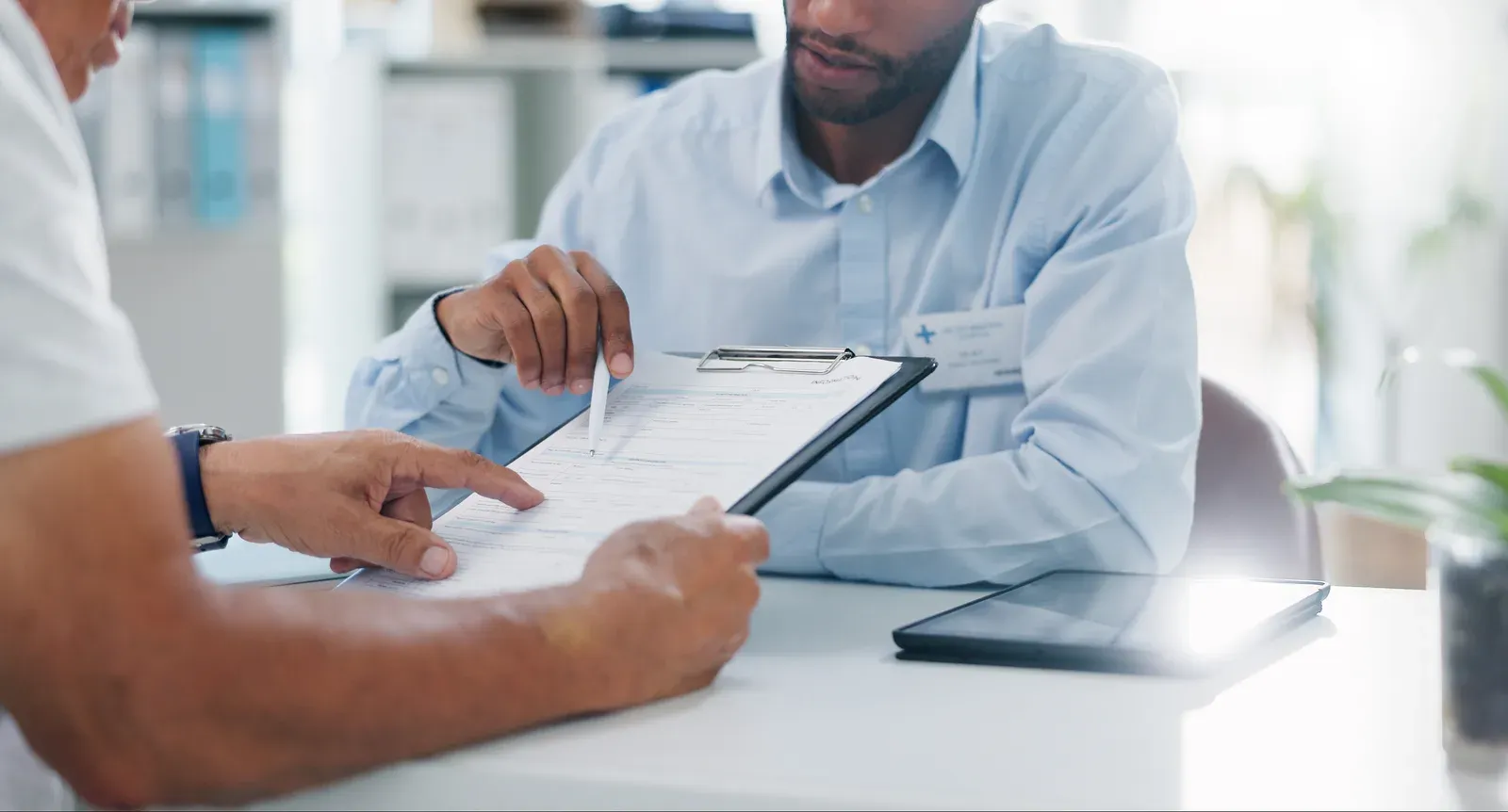 Doctor explaining health insurance paperwork to a patient before they sign