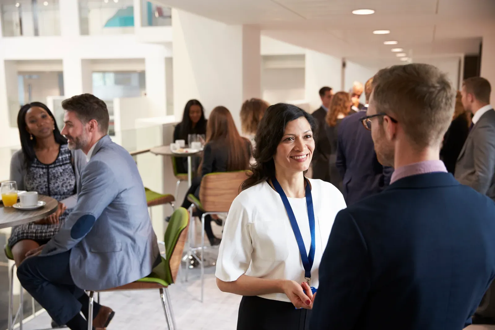 Professionals chatting and networking over coffee during a conference break
