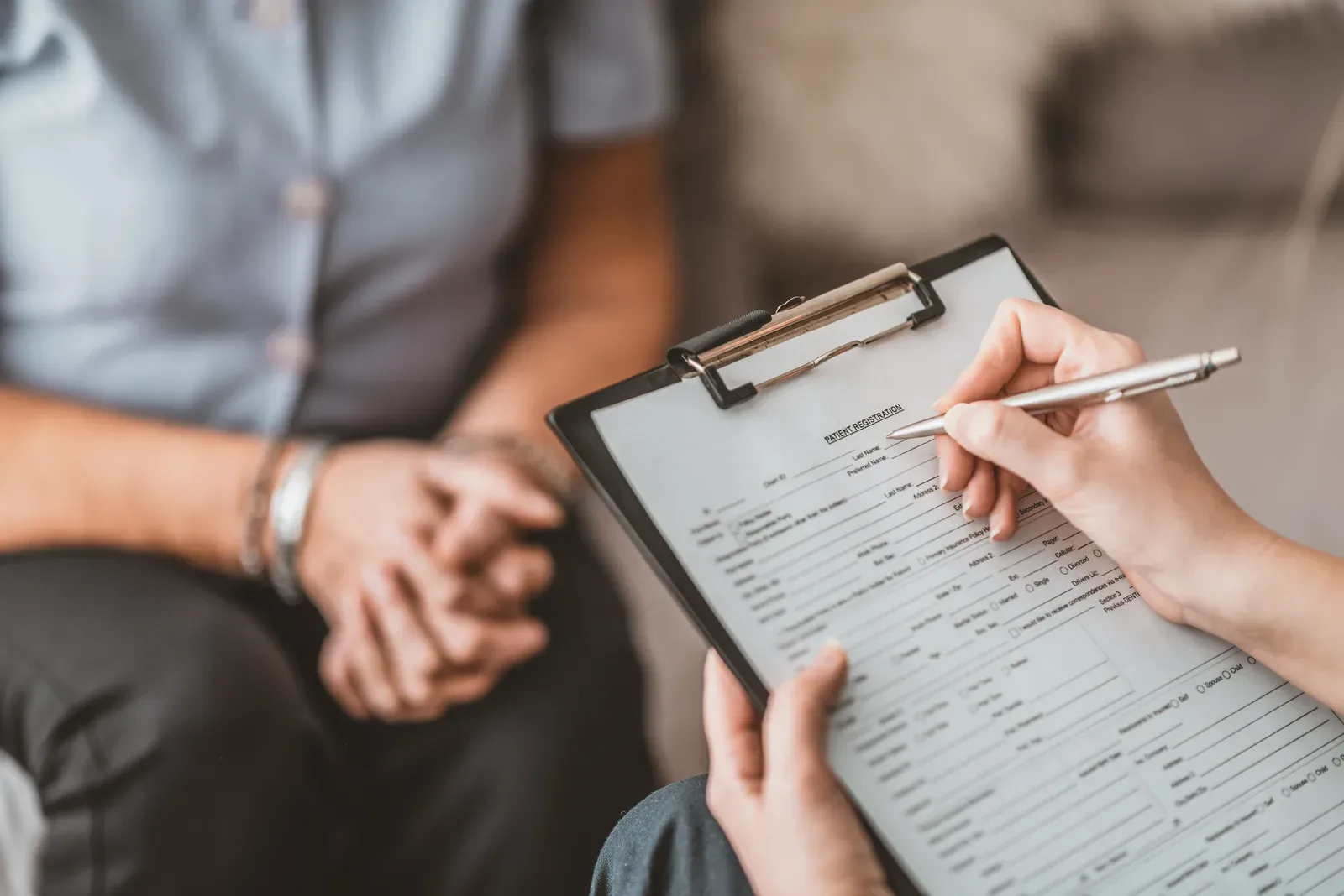 Nurse writing up an assessment with a senior patient
