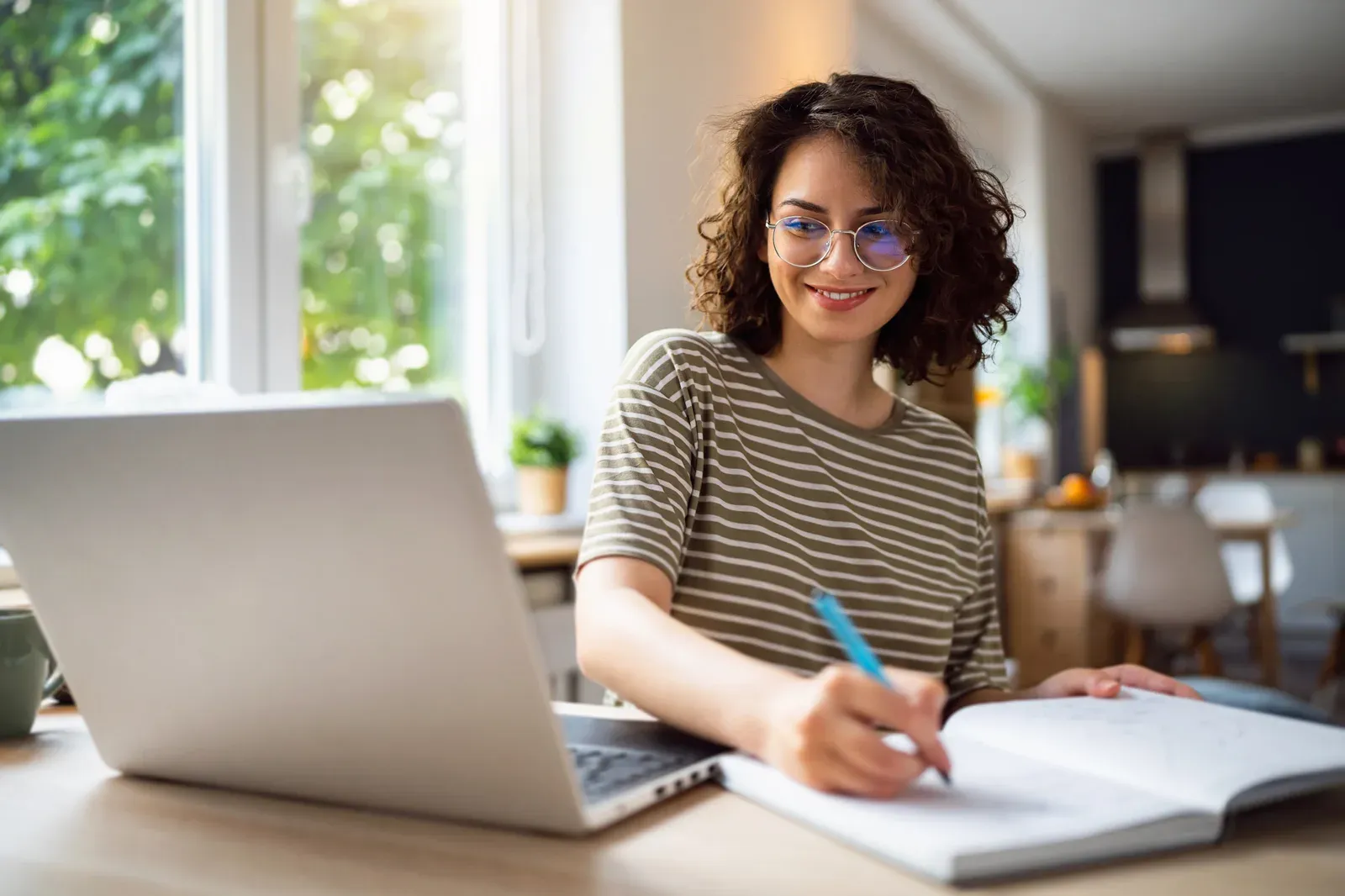 A woman reviewing an online continuing education course on a laptop at her kitchen table