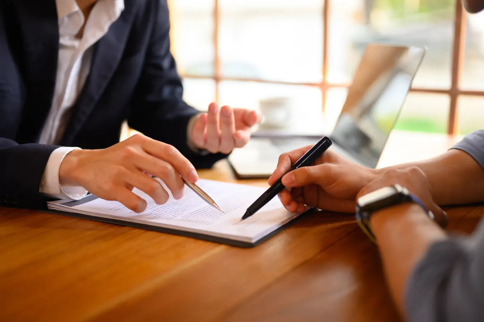 Signing a document at a desk with a pen nearby
