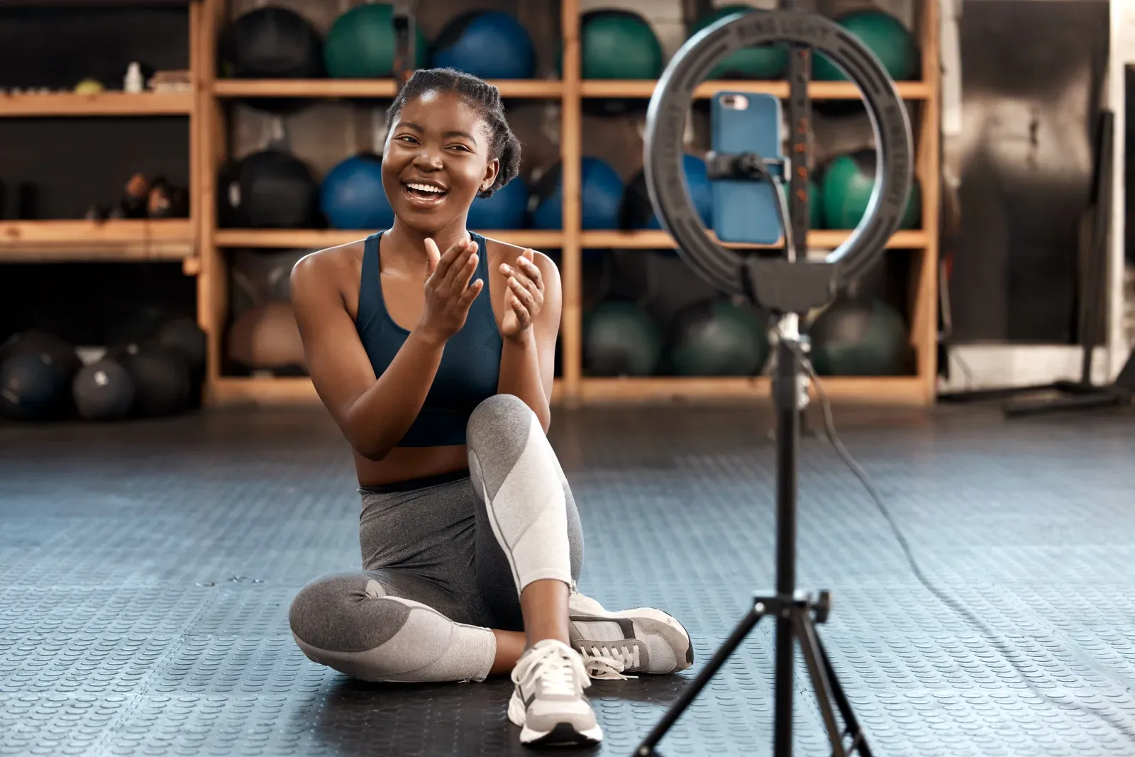 Athletic woman filming her own workout for a fitness account