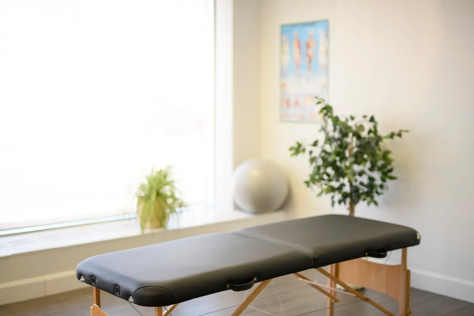 A fold up treatment table positioned in an empty therapy room before a session