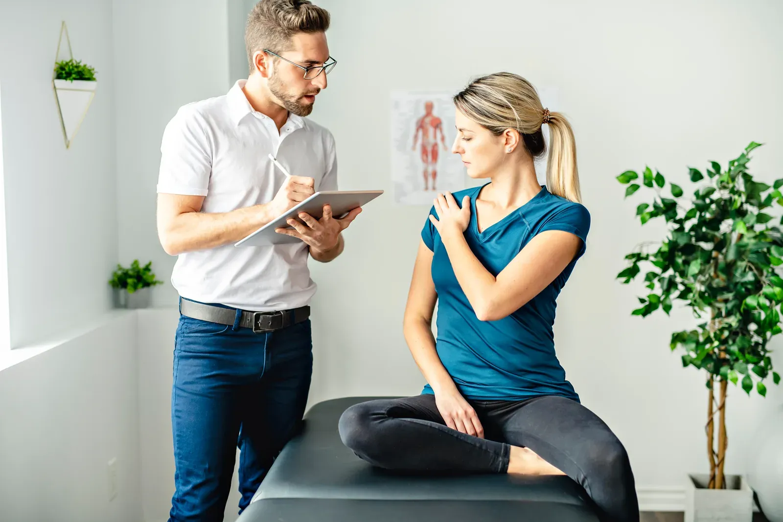 A rehab clinic visit, therapist assessing a patient's shoulder mobility