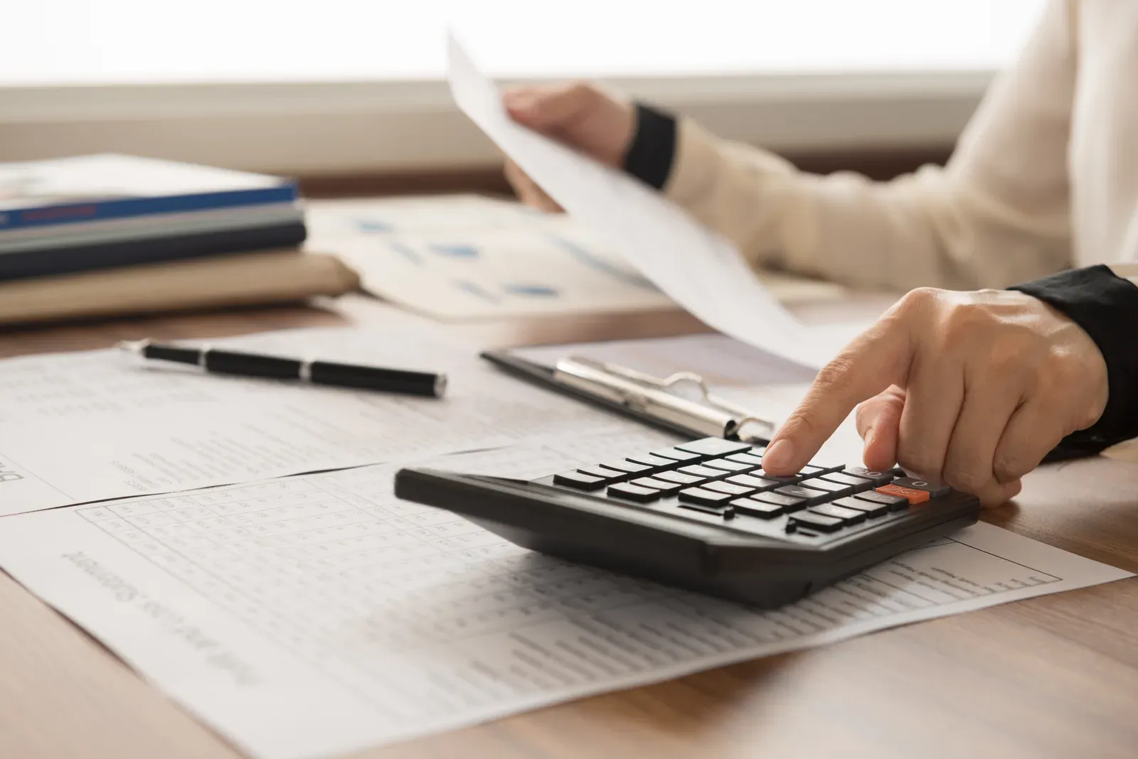 Paycheck and calculator laid out on a desk next to an open notebook
